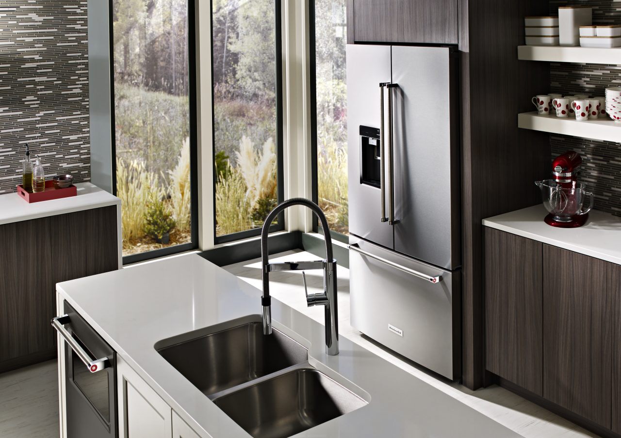 厨房有黑暗的橱柜和不锈钢KitchenAid®冰箱。＂class=